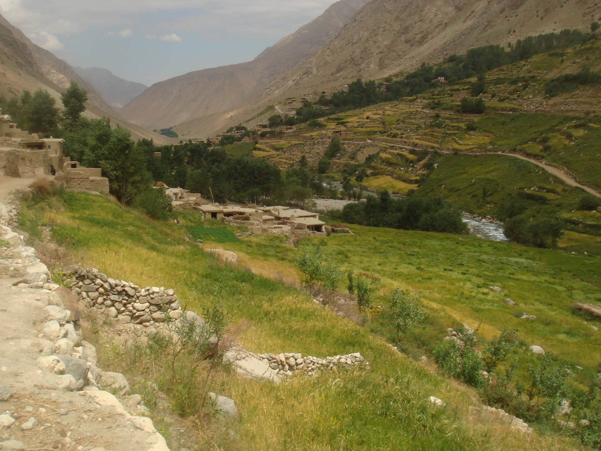 Houses and cultivated terraces beside a river in the mountain valley of Deh Ta, Warsaj District.